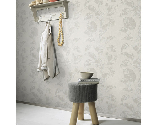 Intérieur décoratif avec papier peint à motifs de feuilles, tabouret, étagère et veste pour une pièce confortable