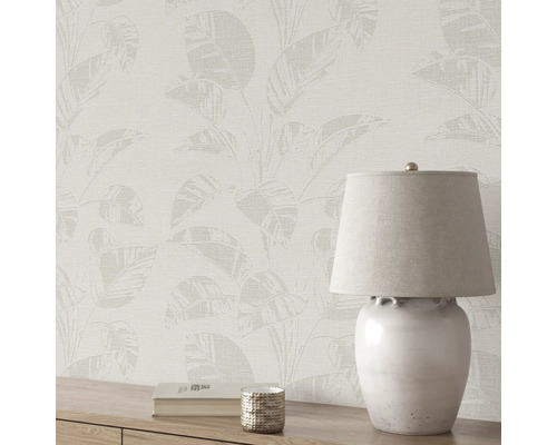 Papier peint à motifs de feuilles et lampe de table sur commode en bois