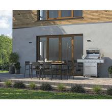 Espace extérieur avec barbecue, table de jardin et chaises devant la maison