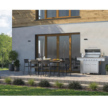 Terrasse mit Grill, Gartentisch und Stühlen vor Hausfassade