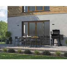 Aussenbereich mit Esstisch, Stühlen und Grill neben dem Haus