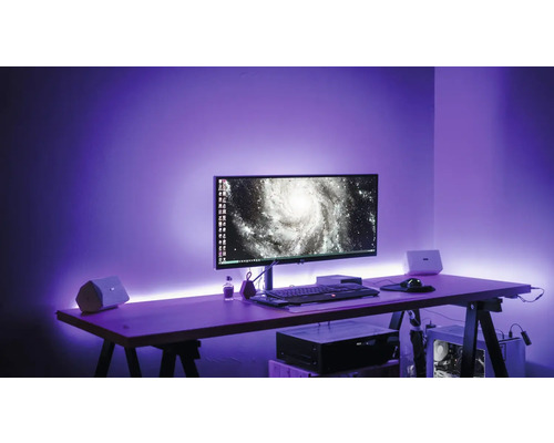 Arbeitsplatz mit Computermonitor, Tastatur, Maus, Lautsprecher und LED-Beleuchtung