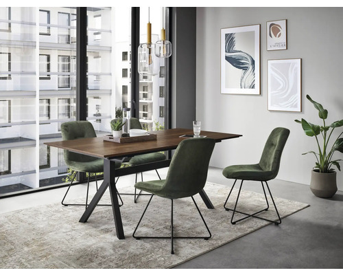 Esstisch mit vier Stühlen in einem hellen Raum mit Bildern an der Wand und einer Zimmerpflanze