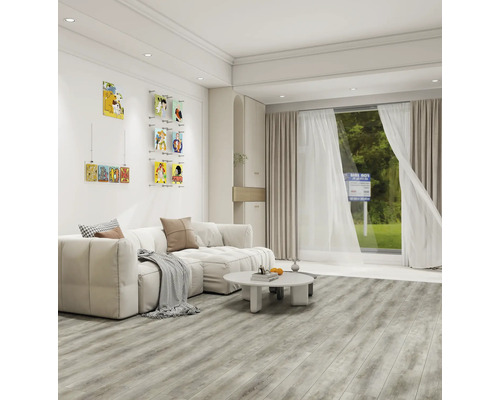 Heller Wohnraum mit Sofa, Couchtisch, Bildern an der Wand und Holzboden