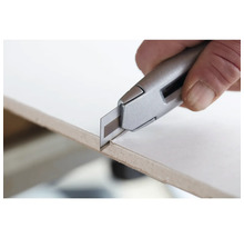 Un cutter coupe une plaque.