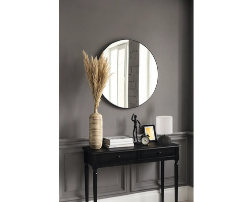 Intérieur décoratif avec console noire, miroir rond, lampe, vase avec herbe de pampa et autres éléments décoratifs