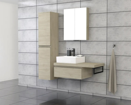 Salle de bains avec lavabo, armoire de toilette et armoire haute devant un mur carrelé