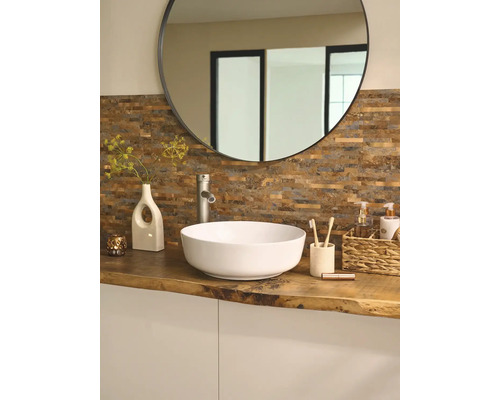 Badezimmer mit rundem Spiegel, Aufsatzwaschbecken, Armatur und Dekoration auf einer Holzplatte