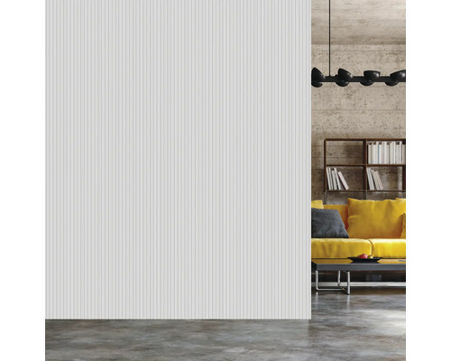 Salon lumineux avec panneaux muraux rainurés, canapé, étagère et lampe