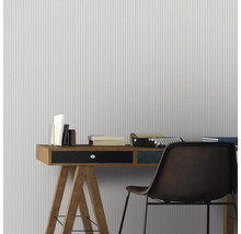 Bureau avec bureau, chaise, livres et machine à écrire devant un papier peint rayé