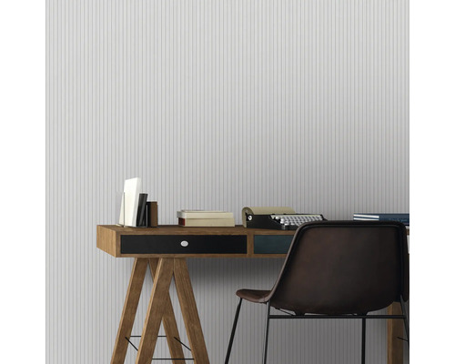 Bureau avec bureau, chaise, livres et machine à écrire devant un papier peint rayé