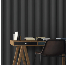 Un espace de travail avec un bureau, une machine à écrire et un mur à lamelles verticales