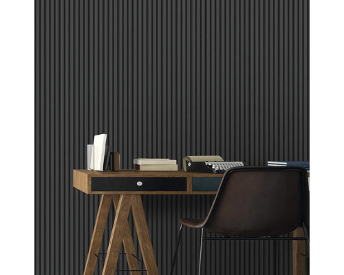 Un espace de travail avec un bureau, une machine à écrire et un mur à lamelles verticales