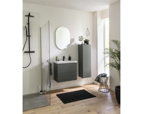 Helles Badezimmer mit Dusche, Waschbeckenunterschrank, Spiegelschrank und ovalem Spiegel