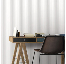 Bureau avec bureau, chaise, machine à écrire et livres devant un papier peint à rayures