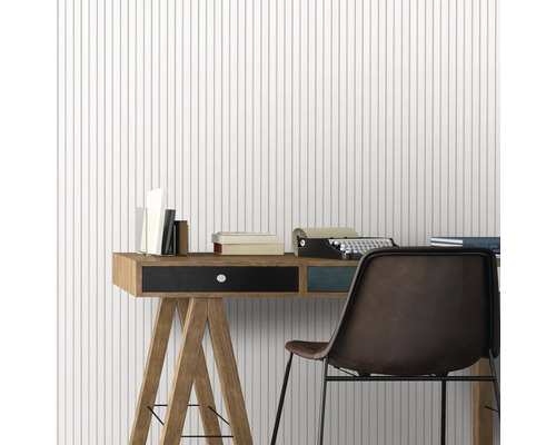 Bureau avec bureau, chaise, machine à écrire et livres devant un papier peint à rayures