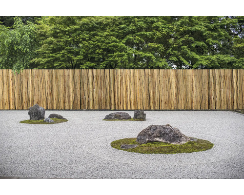 Jardin zen avec clôture en bambou et pierres sur gravier