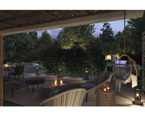 Terrasse éclairée avec mobilier de jardin, coin repas et fauteuil suspendu