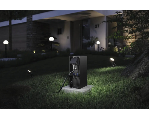 Station de recharge pour véhicules électriques dans le jardin devant une maison