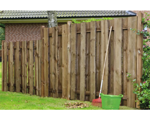 Clôture en bois dans le jardin avec râteau et panier de jardin
