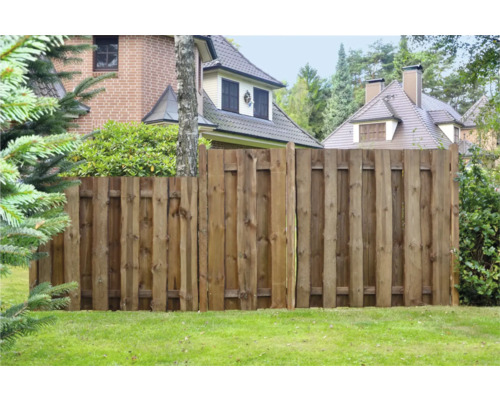 Holzzaun im Gartenbereich mit Häusern im Hintergrund