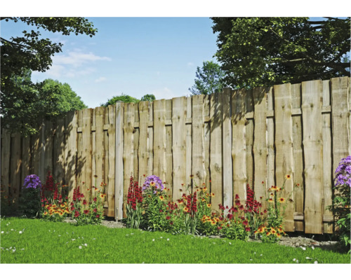 Clôture en bois avec parterre de fleurs dans le jardin.