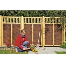 Scène de jardin avec clôture en bois et jardinière au travail