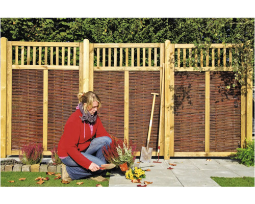 Scène de jardin avec clôture en bois et jardinière au travail