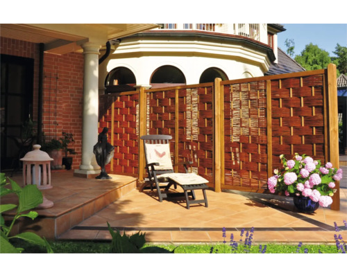 Terrasse avec brise-vue en osier, chaise longue et décoration