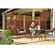 Clôture de protection visuelle en bois et en osier avec coin salon dans le jardin