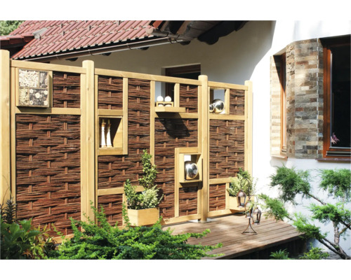 Clôture de protection visuelle en bois et osier avec éléments décoratifs dans le jardin.