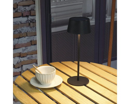 Lampe solaire sur table en bois avec tasse et soucoupe
