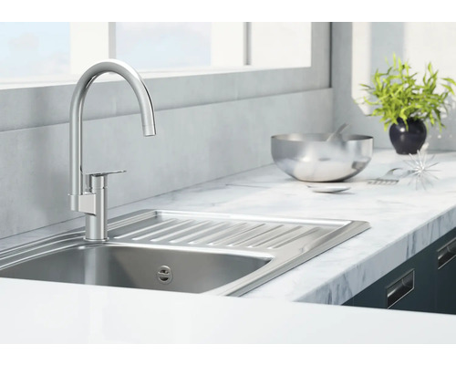 Évier en acier inoxydable avec robinetterie dans une cuisine lumineuse.