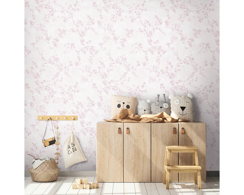 Kinderzimmer mit floral gemusterter Tapete, Holzkommode und Spielzeugdekoration.