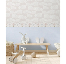 Chambre d''enfant avec papier peint à motifs de nuages et de ballons, banc en bois, lapin en peluche et jouets en bois