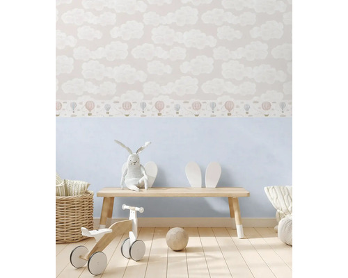 Chambre d''enfant avec papier peint à motifs de nuages et de ballons, banc en bois, lapin en peluche et jouets en bois