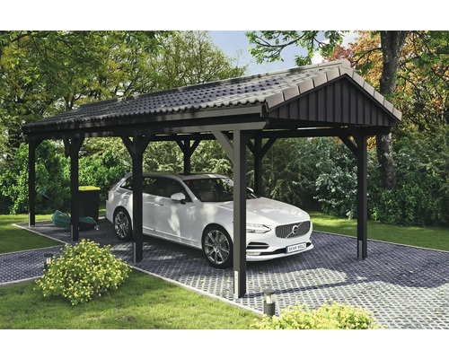 Abri de voiture avec voiture sur sol pavé dans le jardin.