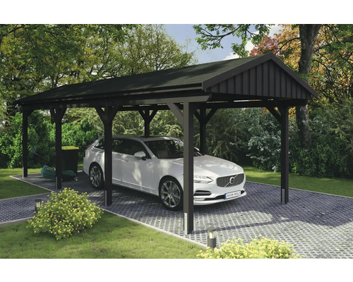 Abri de voiture en bois avec une voiture dans le jardin.