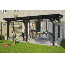 Famille faisant la fête sous une pergola en bois noir dans le jardin