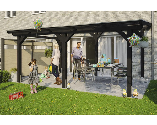 Famille faisant la fête sous une pergola en bois noir dans le jardin