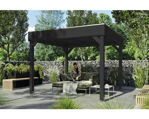 Pavillon de jardin en bois foncé avec une femme assise sur un canapé dans le jardin