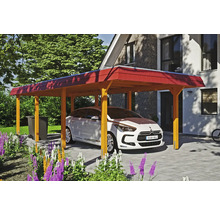 Une voiture est garée sous un carport en bois dans une cour pavée devant une maison.