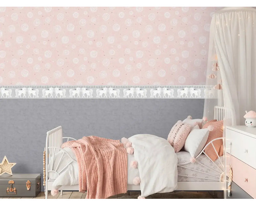 Kinderzimmer mit Bett, Nachttisch und rosafarbener Tapete mit Einhornmuster