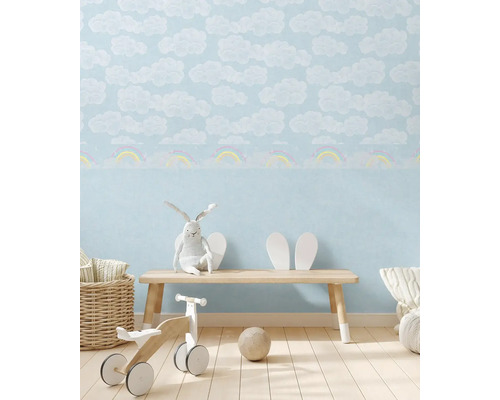 Chambre d''enfant avec papier peint nuages et arc-en-ciel, banc en bois et jouets