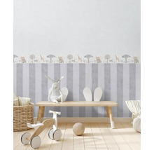 Chambre d''enfant avec papier peint rayé et motifs d''animaux, équipée d''une table en bois, de jouets et de décorations