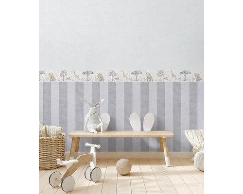 Chambre d''enfant avec papier peint rayé et motifs d''animaux, équipée d''une table en bois, de jouets et de décorations