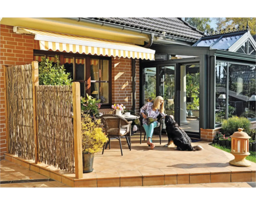 Terrasse mit Markise, Sichtschutzzaun und Frau mit Hund