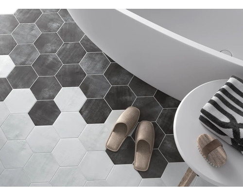 Badezimmer mit sechseckigen Bodenfliesen, Badewanne, Handtuch und Hausschuhen