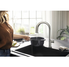 Robinet de cuisine en acier inoxydable au-dessus d''un évier avec une personne remplissant d''eau une casserole.