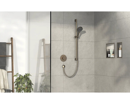 Ensemble de douche avec douchette à main et étagères dans une salle de bains